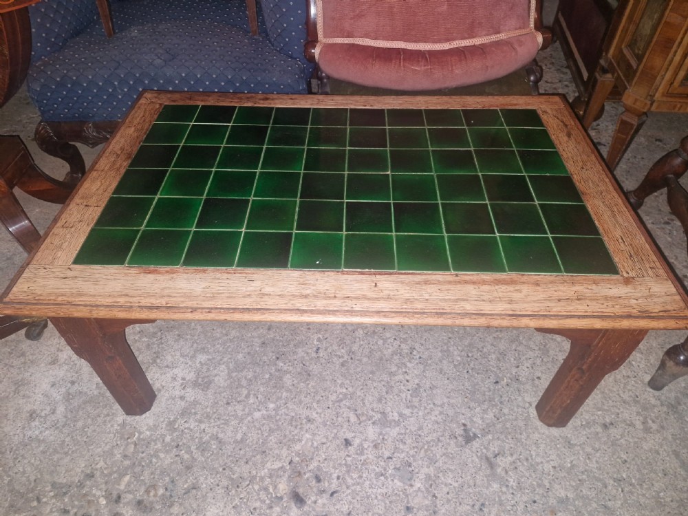 A low rectangular oak coffee table featuring an inset top crafted from square dark green glazed ceramic tiles. View III