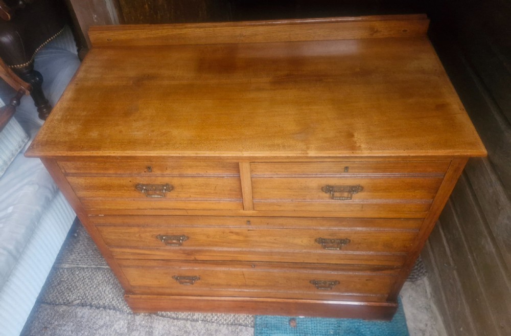 A late Victorian warm brown walnut chest of drawers featuring two short drawers over two long drawers with brass drop handles and a low top gallery. View III