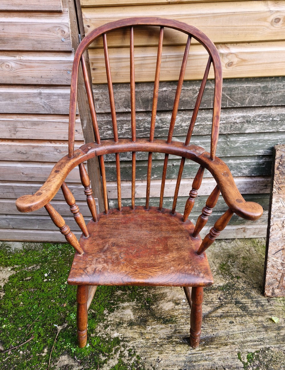 An early 19th-century West Country Windsor armchair with a high hoop back, turned wooden spindles, curved armrests, and a contoured saddle seat. View II