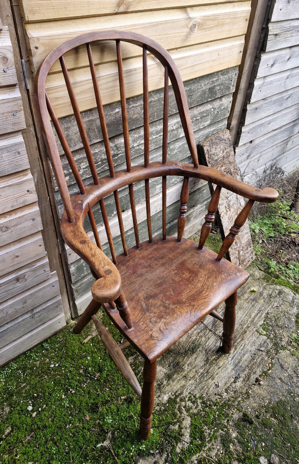 An early 19th-century West Country Windsor armchair with a high hoop back, turned wooden spindles, curved armrests, and a contoured saddle seat. View VI