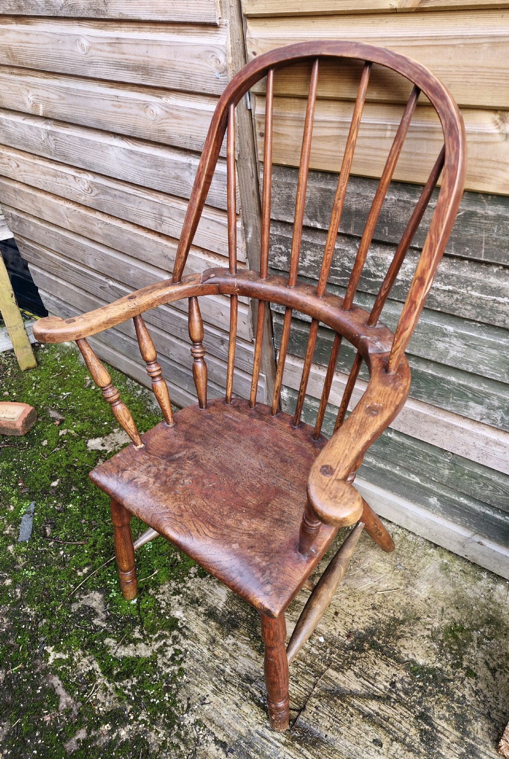 An early 19th-century West Country Windsor armchair with a high hoop back, turned wooden spindles, curved armrests, and a contoured saddle seat. View VII