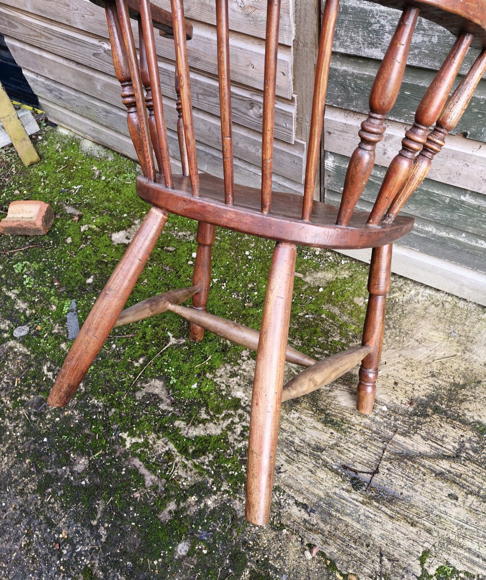 An early 19th-century West Country Windsor armchair with a high hoop back, turned wooden spindles, curved armrests, and a contoured saddle seat. View IX