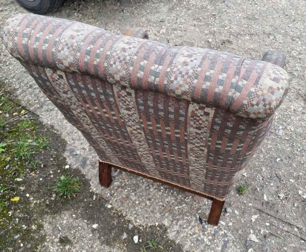 A late Victorian armchair featuring deep button-tufted fabric upholstery, turned front legs, and padded armrests supported by small turned wooden spindles. View IV