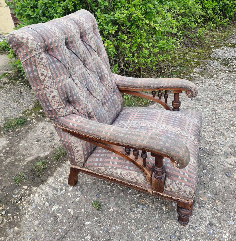 A late Victorian armchair featuring deep button-tufted fabric upholstery, turned front legs, and padded armrests supported by small turned wooden spindles. View VI