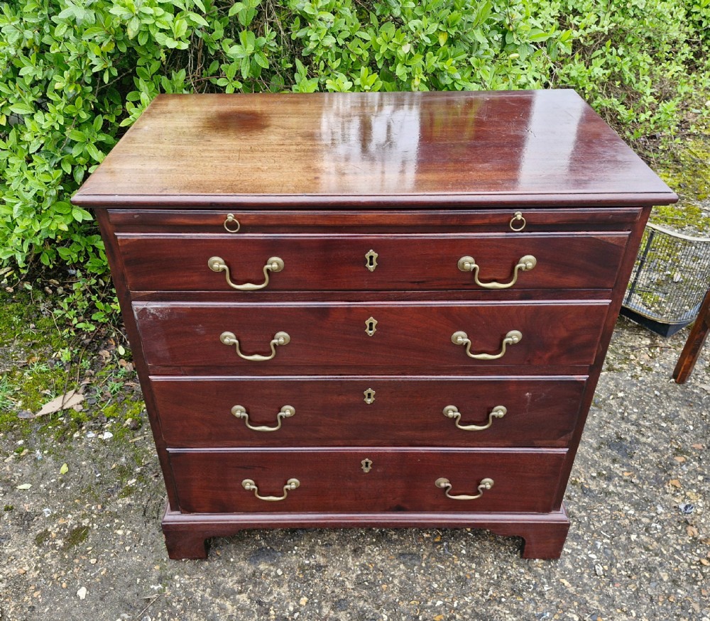 An 18th-century Georgian mahogany chest of drawers featuring four graduated drawers with brass swan-neck handles, a pull-out brushing slide, and bracket feet. View IX