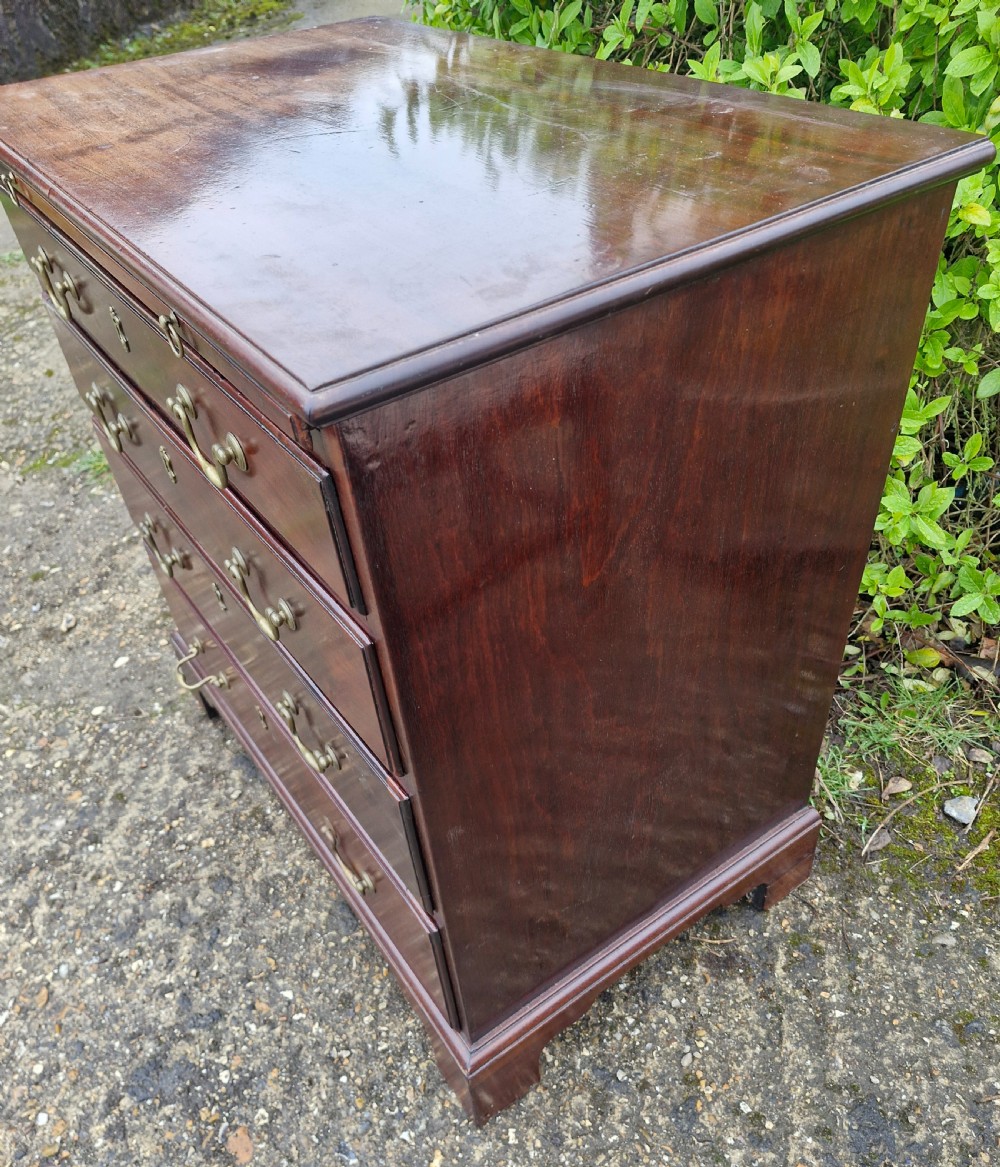 An 18th-century Georgian mahogany chest of drawers featuring four graduated drawers with brass swan-neck handles, a pull-out brushing slide, and bracket feet. View X