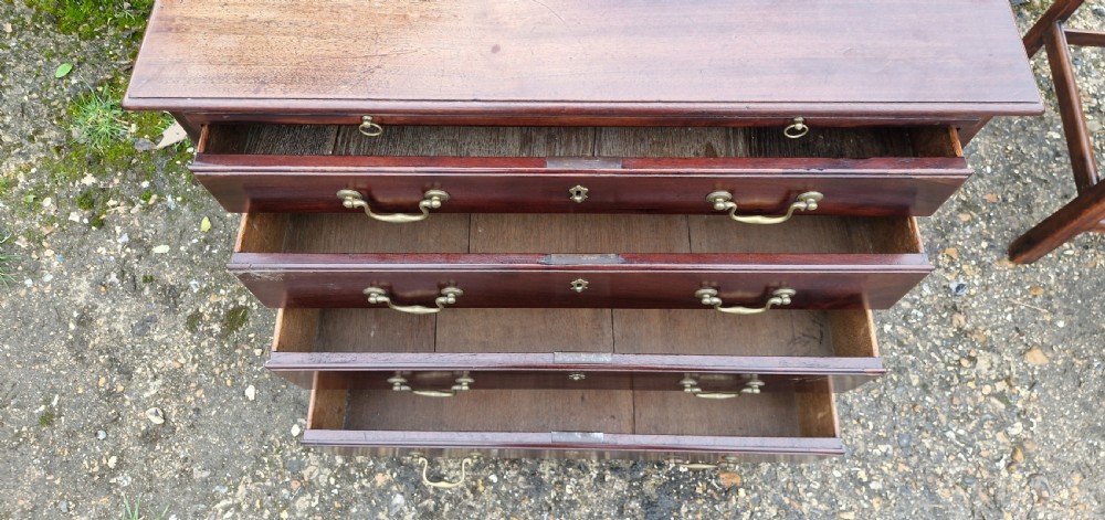 An 18th-century Georgian mahogany chest of drawers featuring four graduated drawers with brass swan-neck handles, a pull-out brushing slide, and bracket feet. View XIII