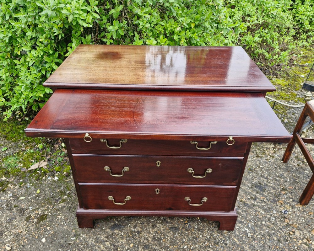 An 18th-century Georgian mahogany chest of drawers featuring four graduated drawers with brass swan-neck handles, a pull-out brushing slide, and bracket feet. View XVII