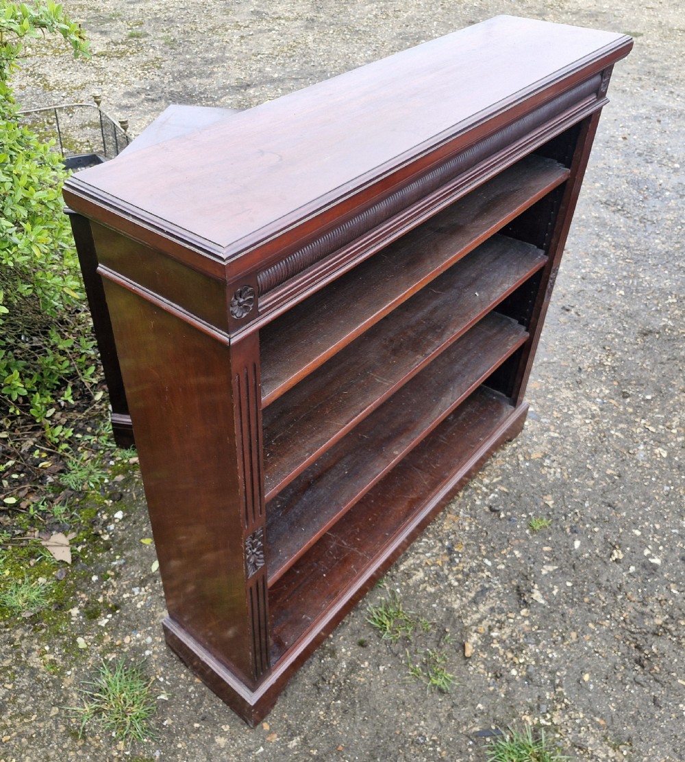 A low late Victorian mahogany open front bookcase featuring four tiers of shelving, reeded pilasters, and carved floral rosettes. View III