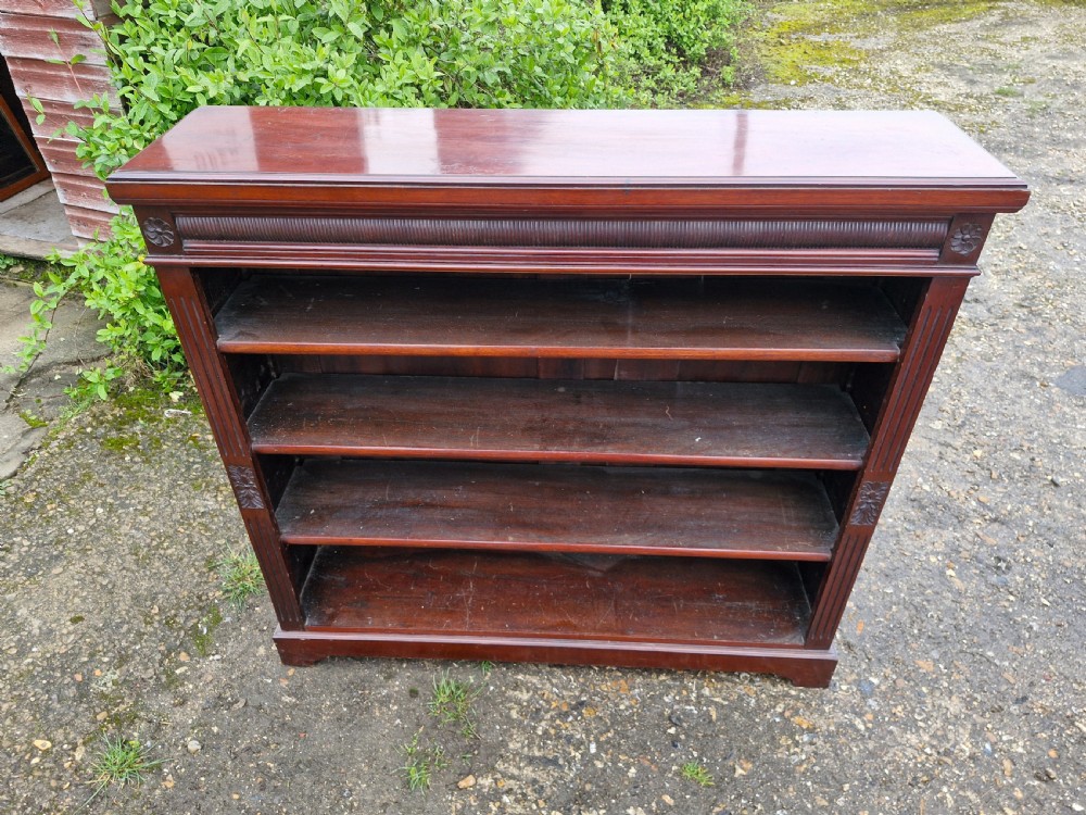 A low late Victorian mahogany open front bookcase featuring four tiers of shelving, reeded pilasters, and carved floral rosettes. View IV