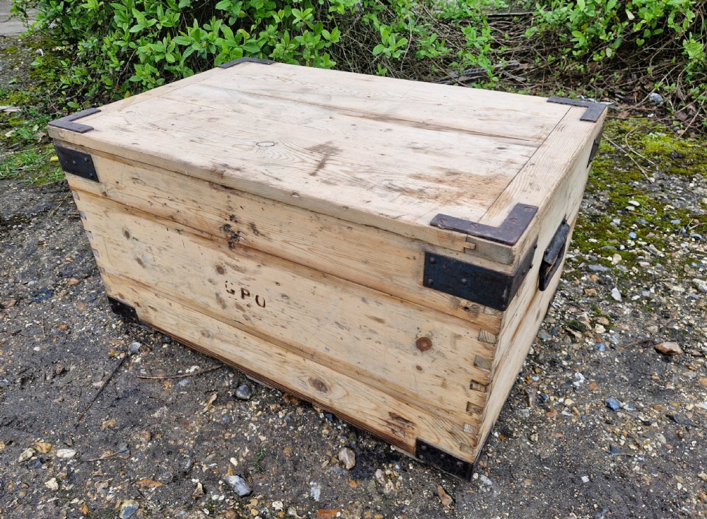 A late Victorian natural pine travelling trunk featuring iron corner brackets, dovetail joinery, and a GPO stencil mark on the front panel.