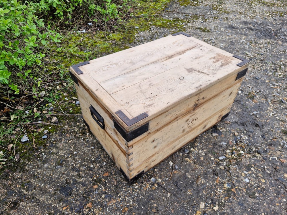 A late Victorian natural pine travelling trunk featuring iron corner brackets, dovetail joinery, and a GPO stencil mark on the front panel. View IV