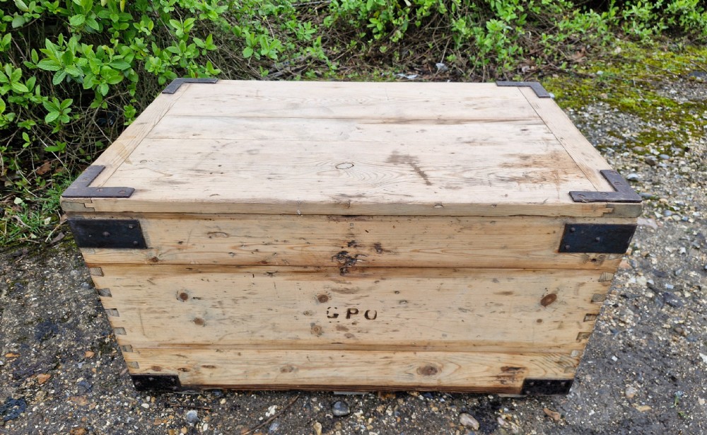 A late Victorian natural pine travelling trunk featuring iron corner brackets, dovetail joinery, and a GPO stencil mark on the front panel. View V