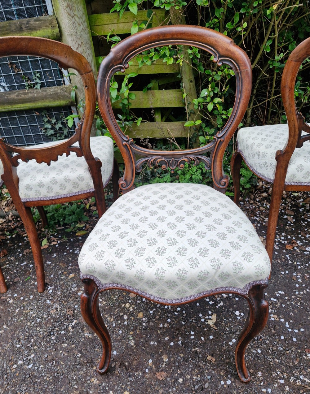 A set of six Victorian walnut balloon back dining chairs featuring carved back splats, cabriole front legs, and pattern-upholstered seats. View II