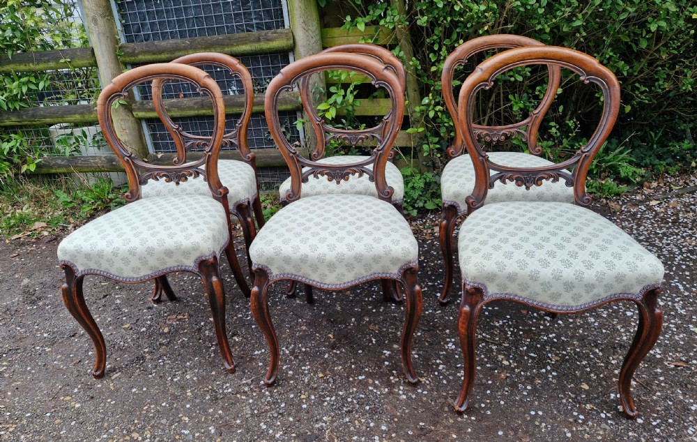A set of six Victorian walnut balloon back dining chairs featuring carved back splats, cabriole front legs, and pattern-upholstered seats. View IX