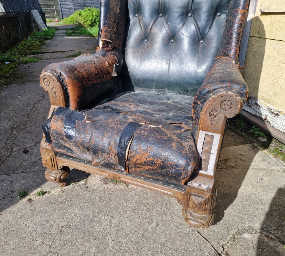 A Victorian library armchair featuring deep buttoned dark leather upholstery with carved wooden arm supports and feet. View IV