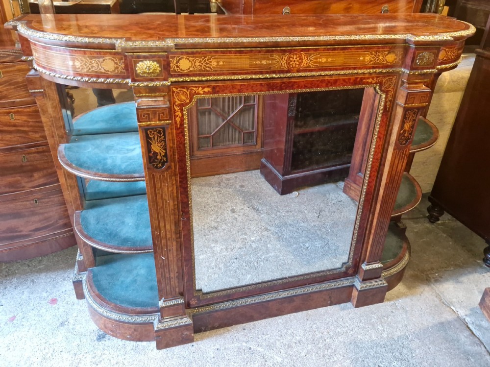 An antique burr walnut side cabinet featuring intricate marquetry inlays, gilt bronze mounts, a central mirror, and open curved side shelves lined in green velvet. View II