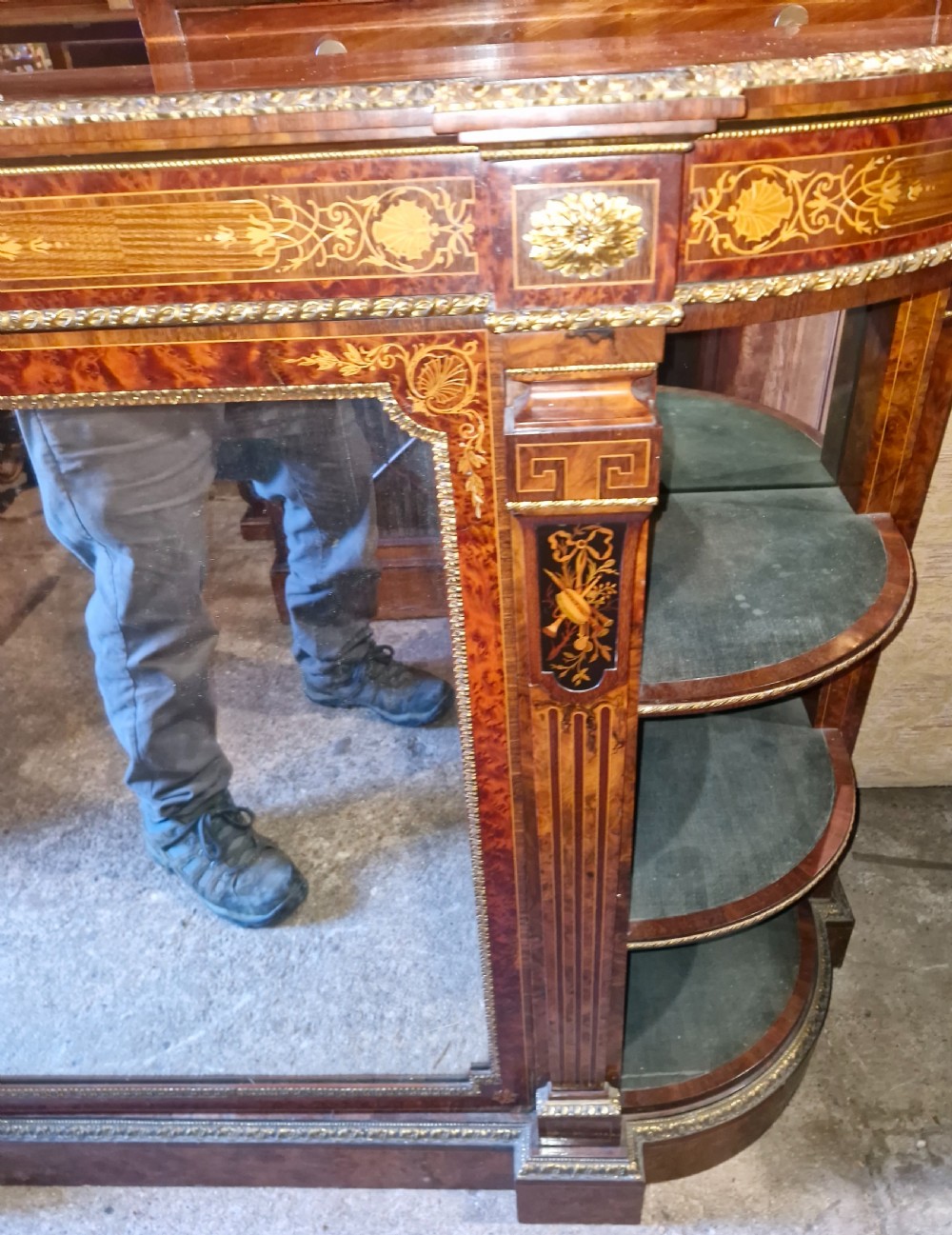 An antique burr walnut side cabinet featuring intricate marquetry inlays, gilt bronze mounts, a central mirror, and open curved side shelves lined in green velvet. View VII