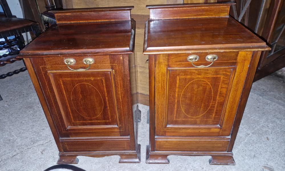A matched pair of dark mahogany cabinets featuring satinwood stringing, central oval inlaid panels, brass bail handles, and bracket feet. View V