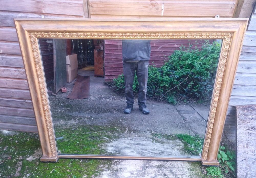 A large 19th-century rectangular overmantel mirror featuring an ornate gilded frame with classical repeating egg-and-dart moulding. View V