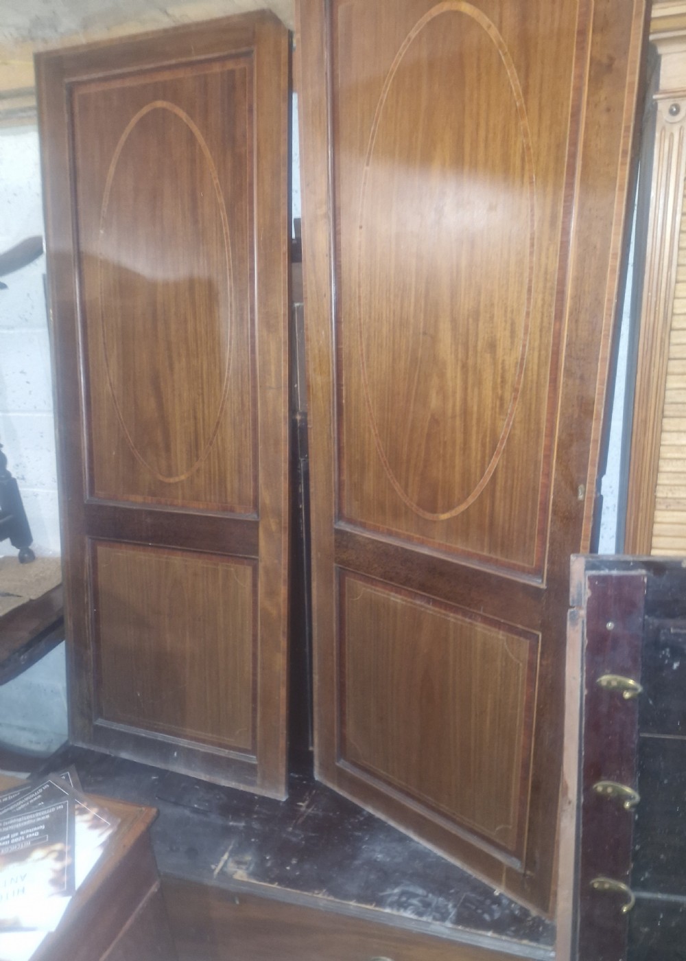 A pair of nineteenth-century mahogany wardrobe doors featuring central oval inlay panels and rectangular lower framing.