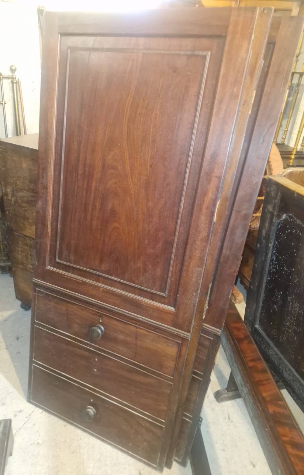 A Late Georgian mahogany wardrobe featuring two large panelled doors above multiple lower drawers with turned wooden knobs. View III