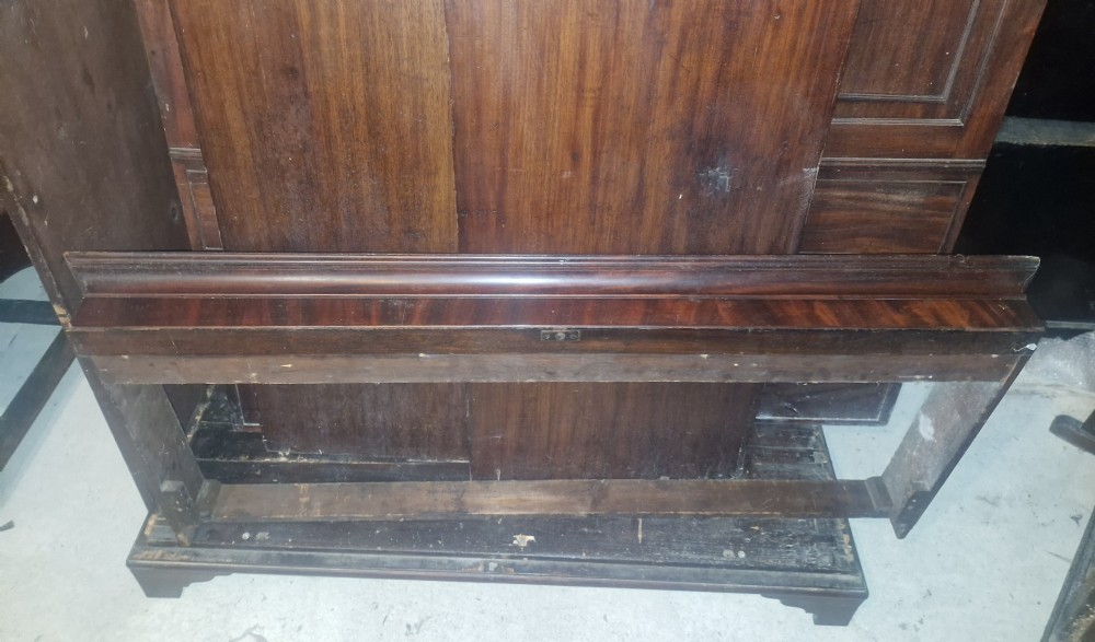 A Late Georgian mahogany wardrobe featuring two large panelled doors above multiple lower drawers with turned wooden knobs. View V