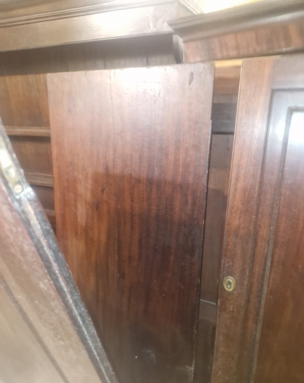 A Late Georgian mahogany wardrobe featuring two large panelled doors above multiple lower drawers with turned wooden knobs. View VI