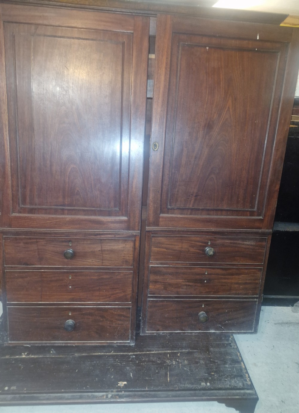 A Late Georgian mahogany wardrobe featuring two large panelled doors above multiple lower drawers with turned wooden knobs. View VIII