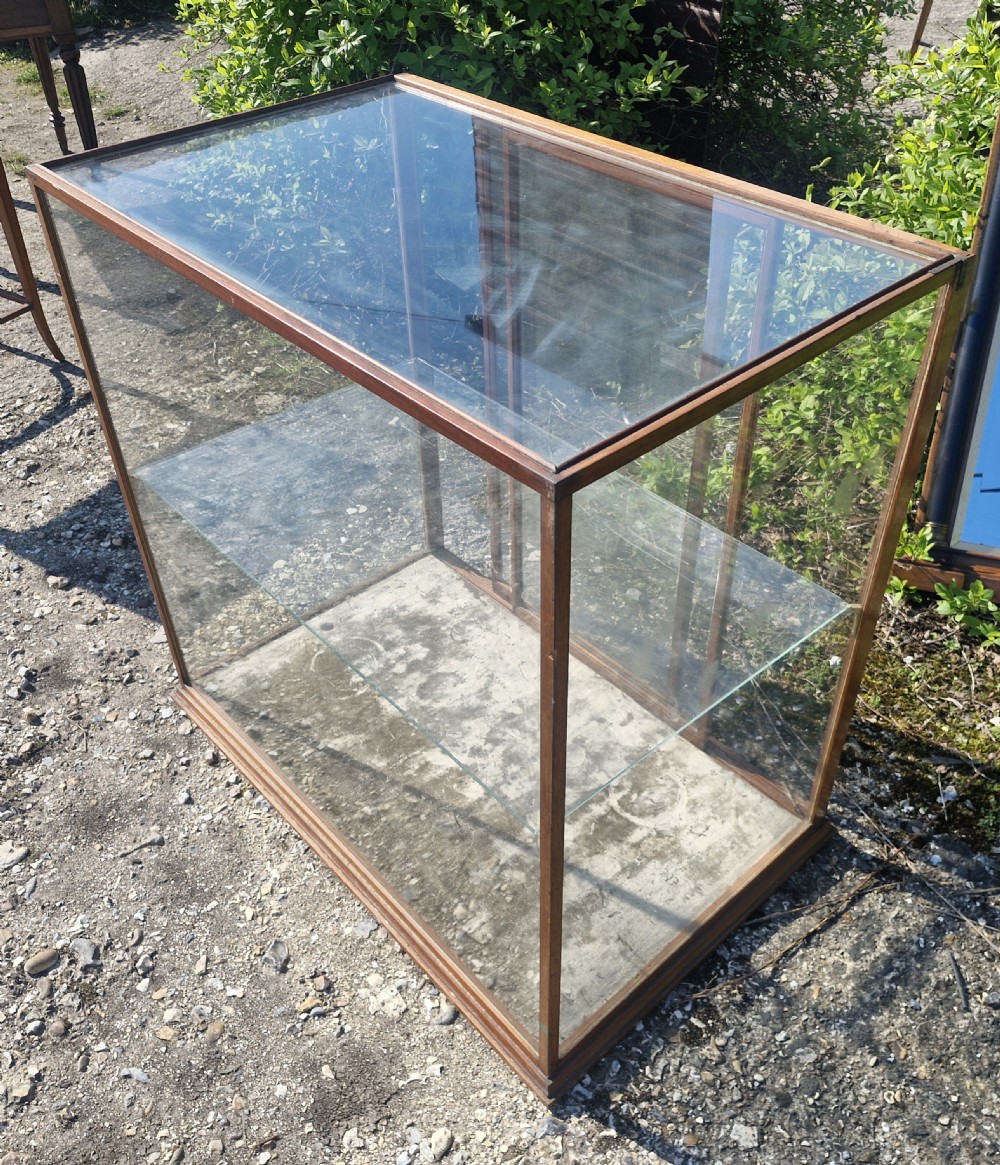A rectangular glazed tabletop shop display cabinet featuring a dark mahogany timber frame, glass side panels, a glass top, and a single internal glass shelf.