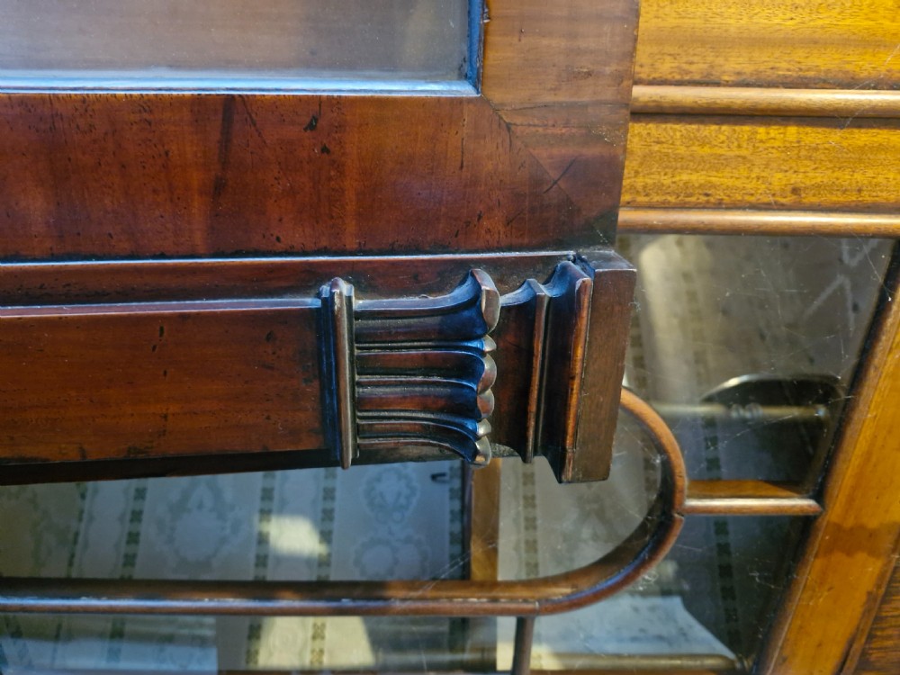 A large Regency breakfront mahogany library bookcase featuring glazed upper doors and panelled lower cupboard doors. View V