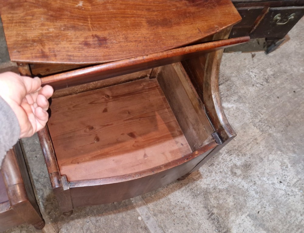 A pair of late Georgian mahogany two-tiered bedside tables with turned front legs and curved side supports. View II
