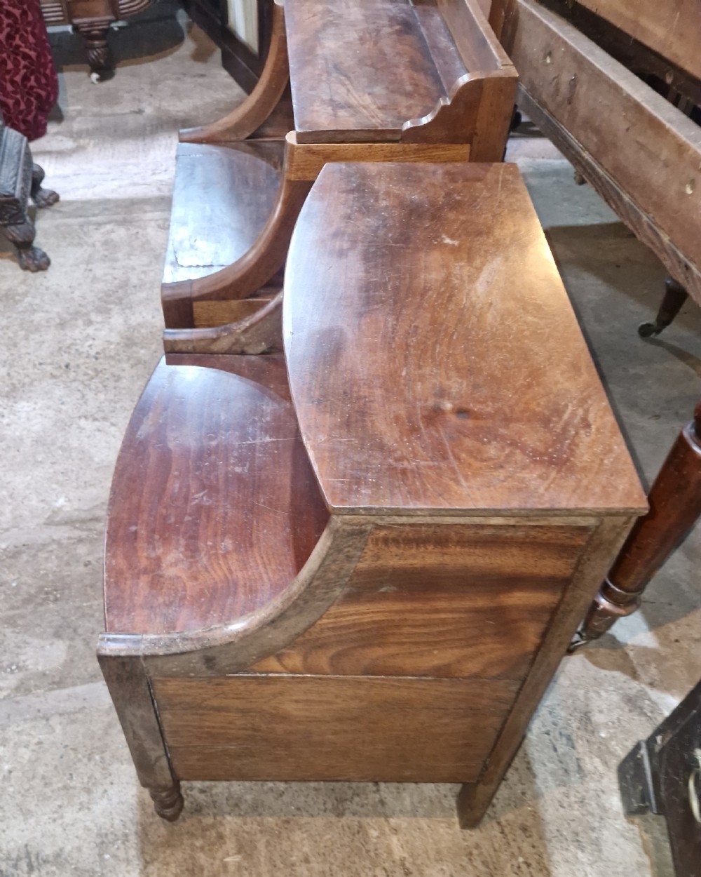A pair of late Georgian mahogany two-tiered bedside tables with turned front legs and curved side supports. View III