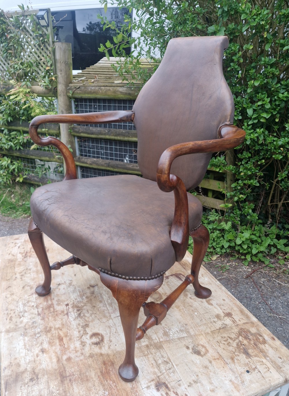 A Queen Anne style desk armchair featuring dark brown leather upholstery, scroll arms, and cabriole legs with turned stretchers. View V