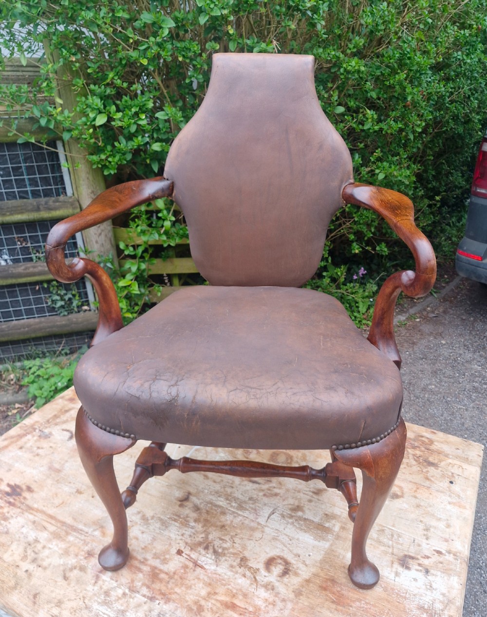 A Queen Anne style desk armchair featuring dark brown leather upholstery, scroll arms, and cabriole legs with turned stretchers. View VII