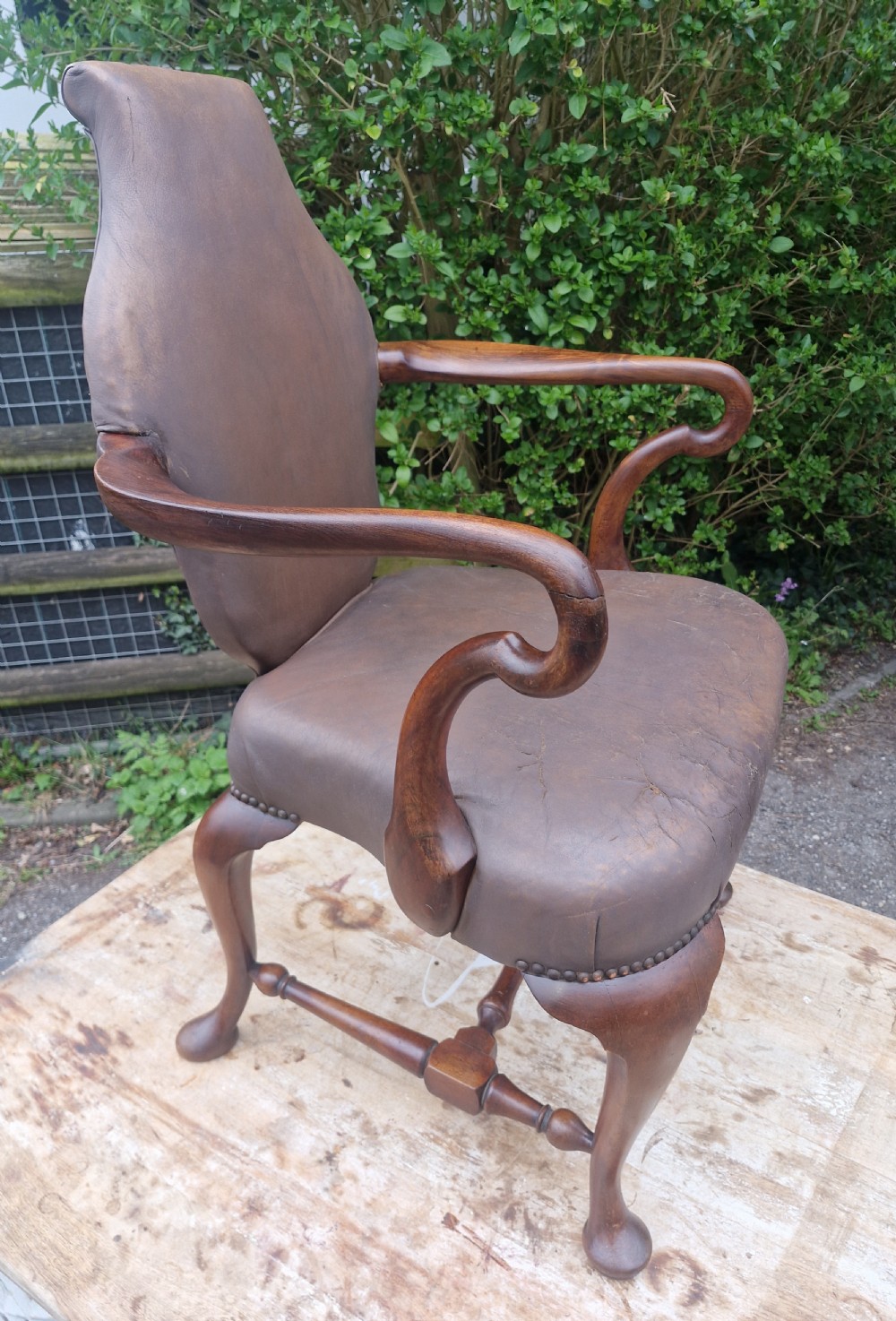 A Queen Anne style desk armchair featuring dark brown leather upholstery, scroll arms, and cabriole legs with turned stretchers. View VIII