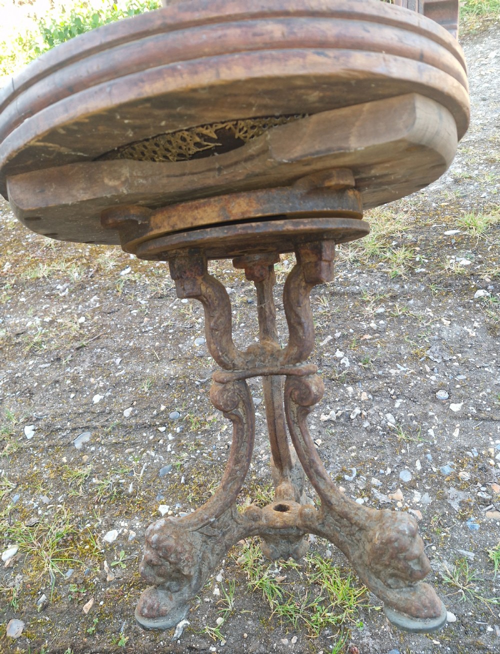 A pair of antique wooden ocean liner revolving armchairs featuring carved monograms on the back splats and cast iron swivel bases. View III