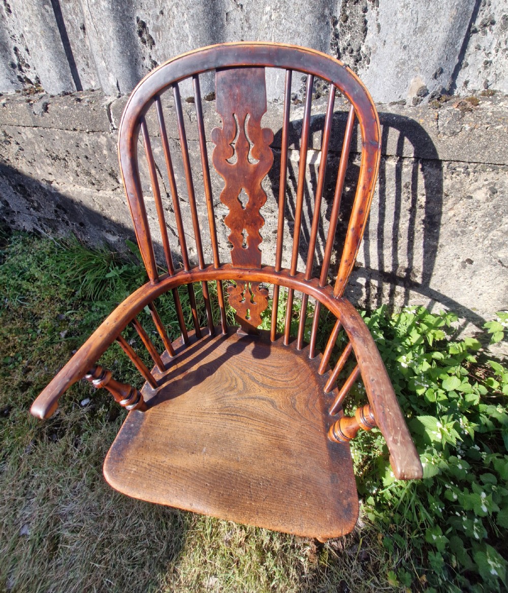 A mid-19th-century yewwood Windsor armchair featuring a hoop back, pierced central splat, turned legs, and a saddle-shaped wooden seat. View II