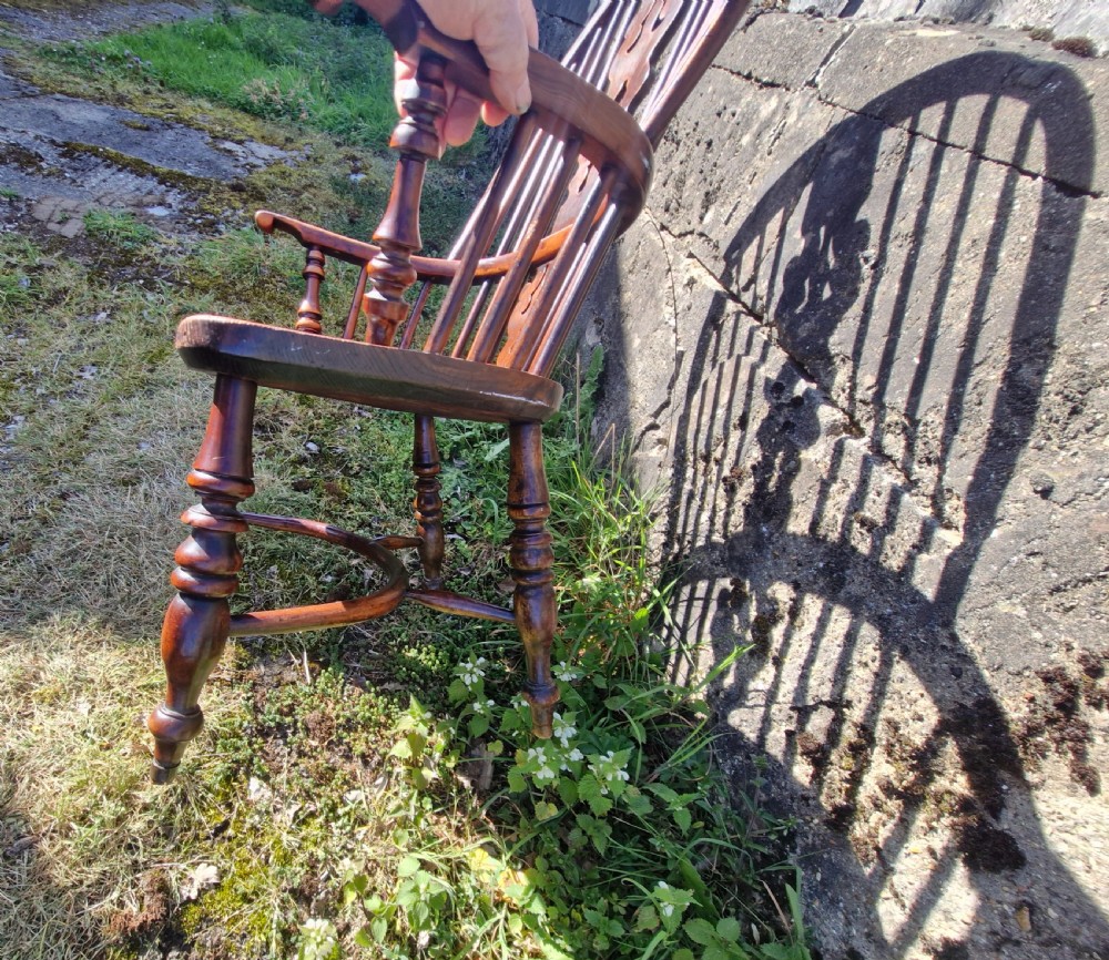 A mid-19th-century yewwood Windsor armchair featuring a hoop back, pierced central splat, turned legs, and a saddle-shaped wooden seat. View IV
