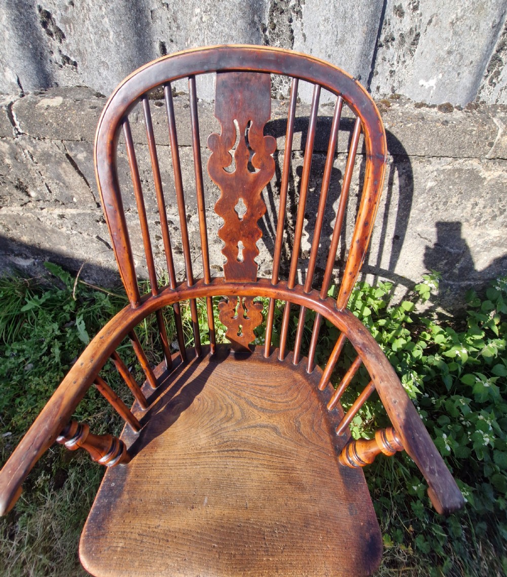 A mid-19th-century yewwood Windsor armchair featuring a hoop back, pierced central splat, turned legs, and a saddle-shaped wooden seat. View V
