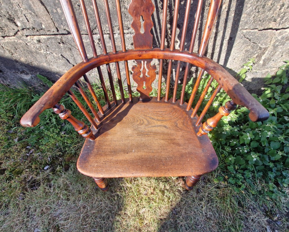 A mid-19th-century yewwood Windsor armchair featuring a hoop back, pierced central splat, turned legs, and a saddle-shaped wooden seat. View VI