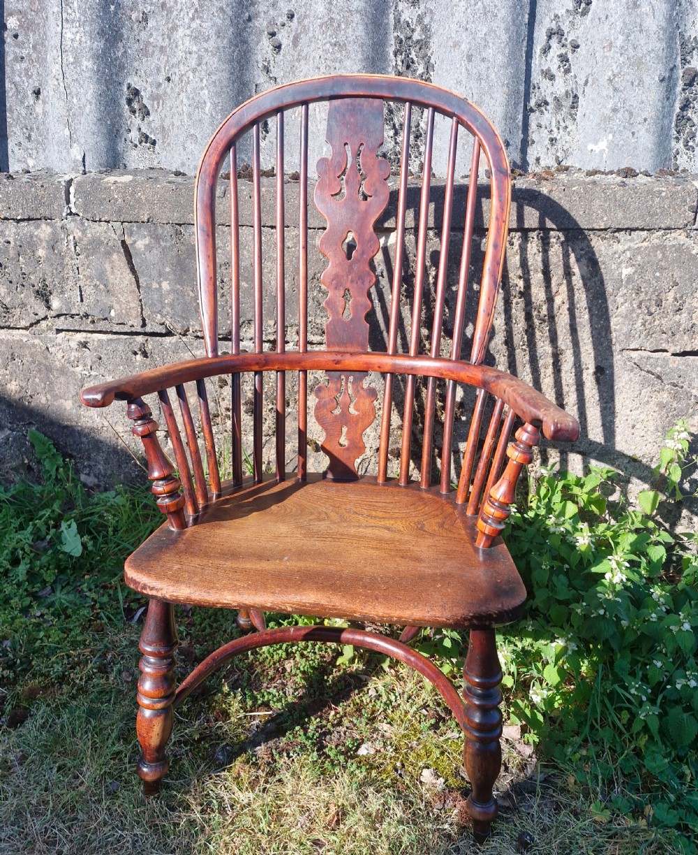 A mid-19th-century yewwood Windsor armchair featuring a hoop back, pierced central splat, turned legs, and a saddle-shaped wooden seat. View IX
