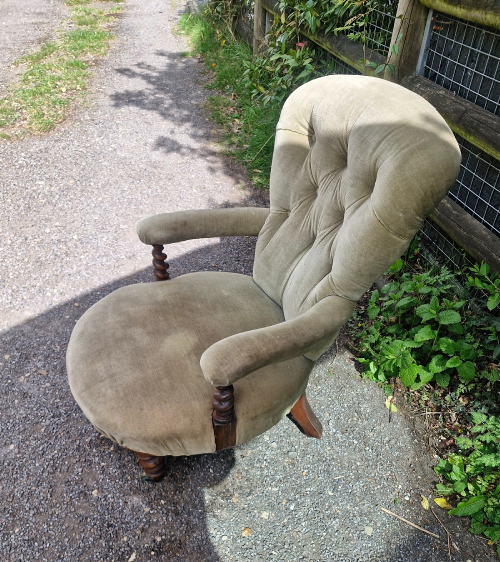 A mid-Victorian armchair upholstered in sage green velvet featuring a deep buttoned backrest, padded arms on barley twist supports, and turned legs with castors. View III
