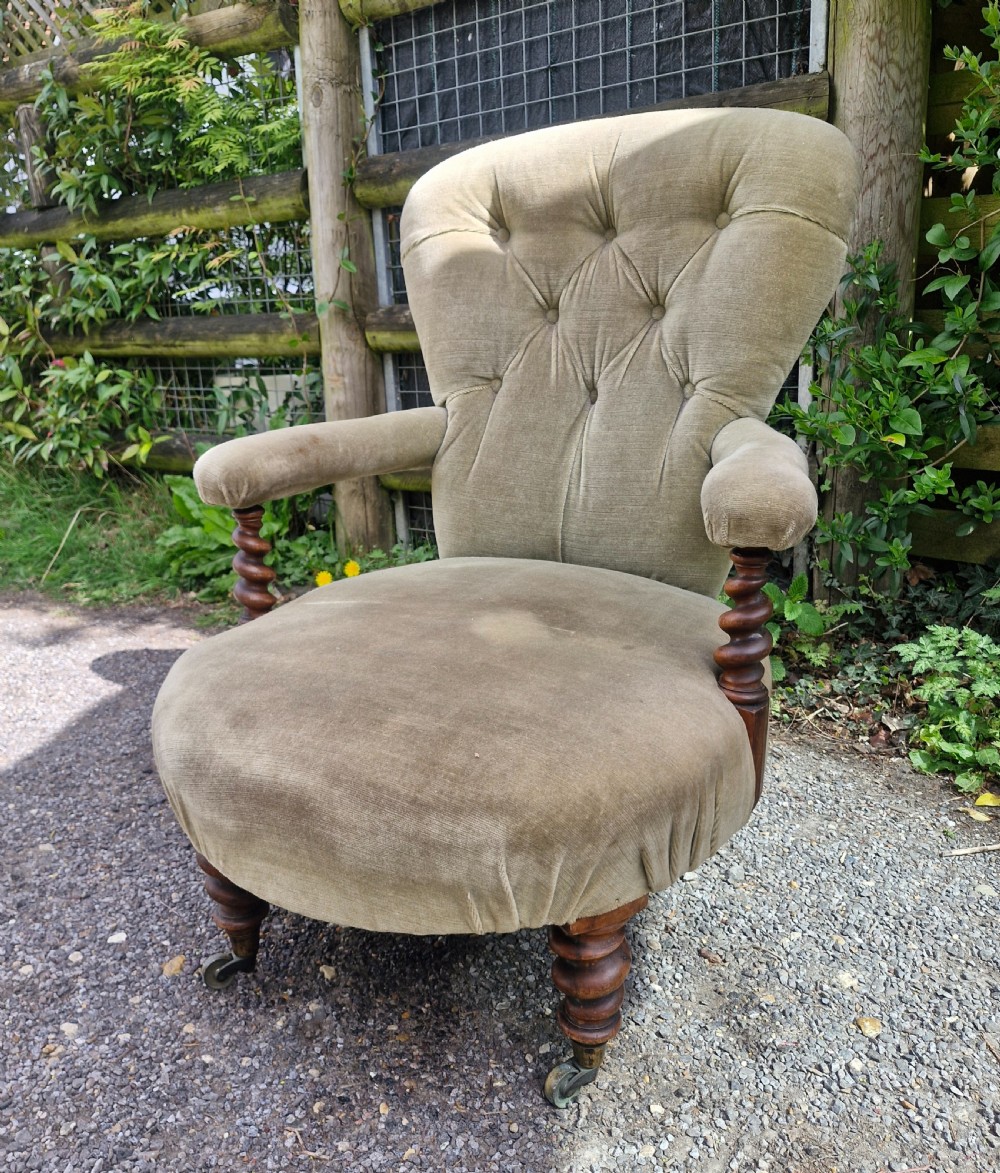 A mid-Victorian armchair upholstered in sage green velvet featuring a deep buttoned backrest, padded arms on barley twist supports, and turned legs with castors. View IV