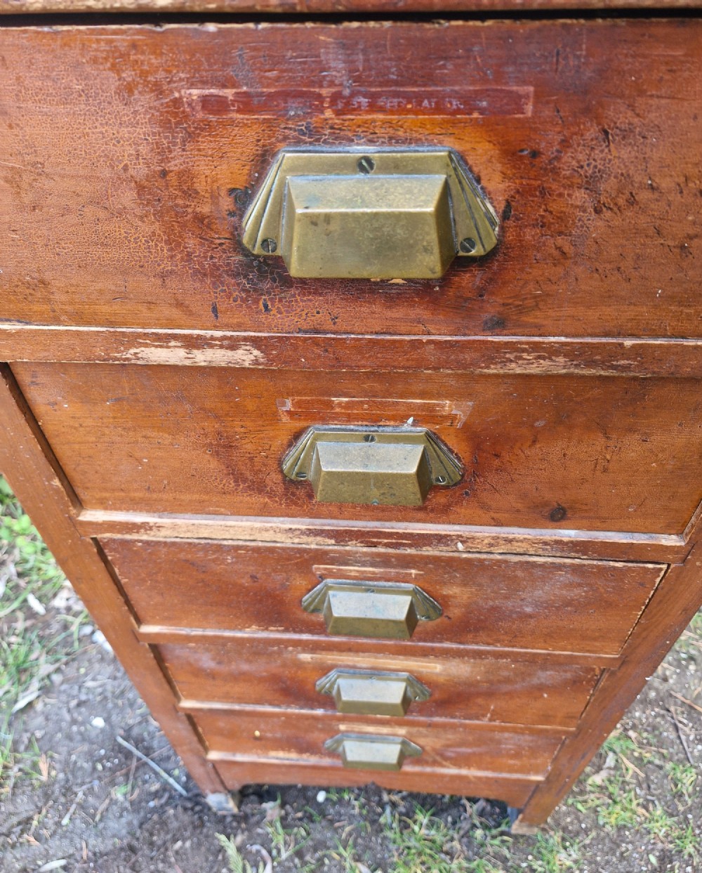 A medium brown vintage wooden five-drawer vertical office cabinet with brass cup handles. View II