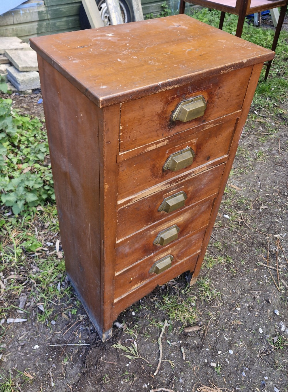 A medium brown vintage wooden five-drawer vertical office cabinet with brass cup handles. View V