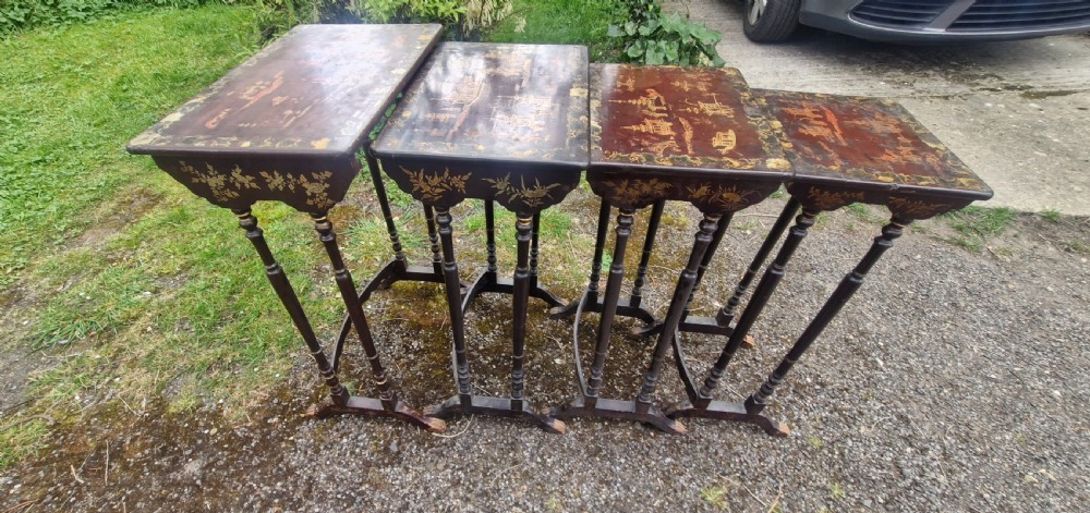 A set of four dark brown lacquered nesting tables decorated with hand-painted gilt chinoiserie landscape scenes and slender turned legs. View IV