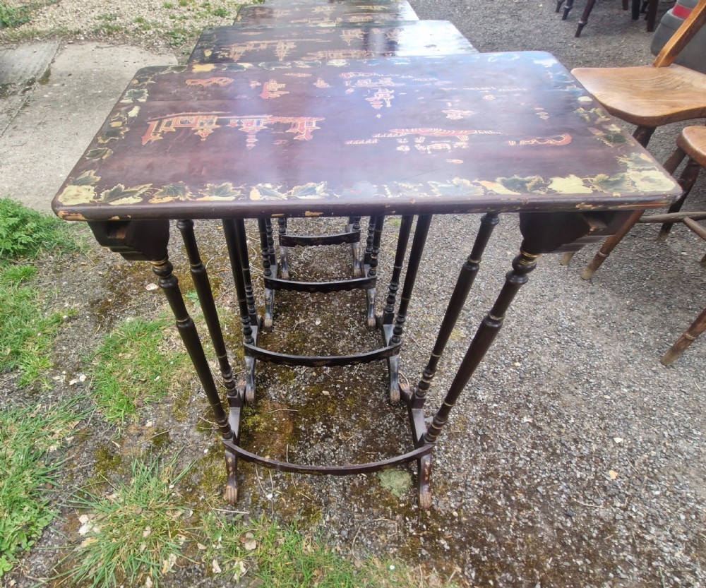 A set of four dark brown lacquered nesting tables decorated with hand-painted gilt chinoiserie landscape scenes and slender turned legs. View VII
