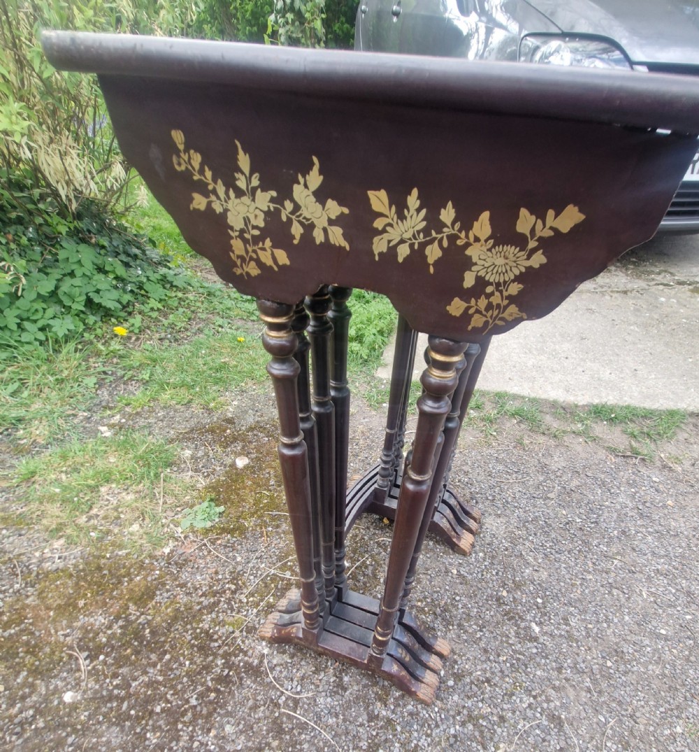 A set of four dark brown lacquered nesting tables decorated with hand-painted gilt chinoiserie landscape scenes and slender turned legs. View VIII