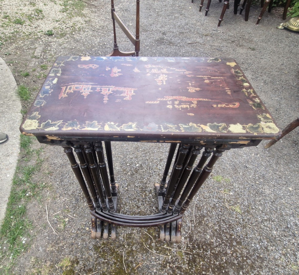 A set of four dark brown lacquered nesting tables decorated with hand-painted gilt chinoiserie landscape scenes and slender turned legs. View XII